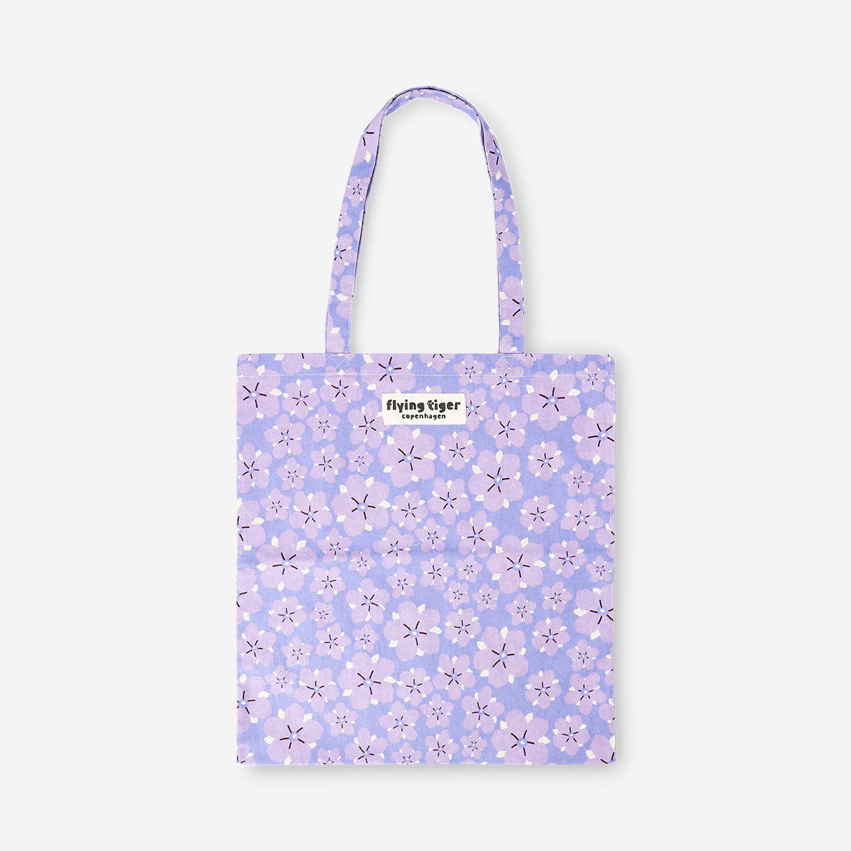 Purple floral tote bag made of textile with Flying Tiger Copenhagen branding, featuring a vibrant flower pattern.